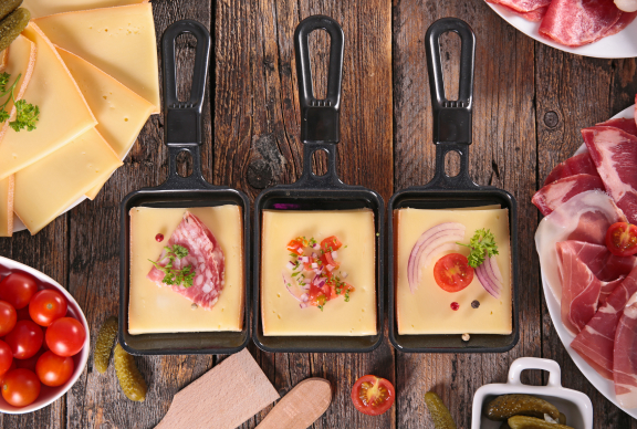 Queso Raclette fundido en bandeja con otros ingredientes